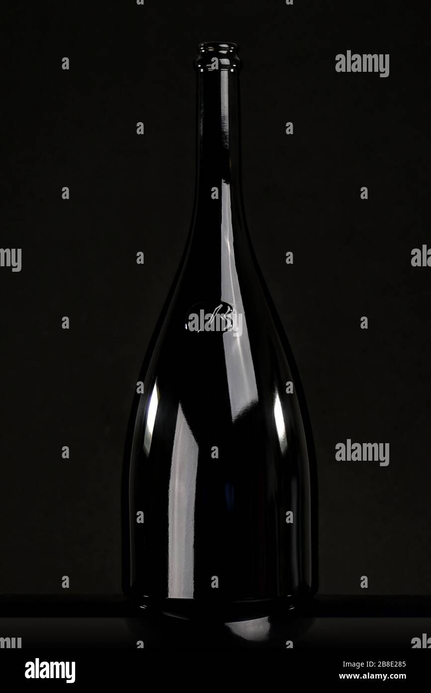Schwarze Glasflasche Wein auf schwarzem Hintergrund, Stillleben Stockfoto