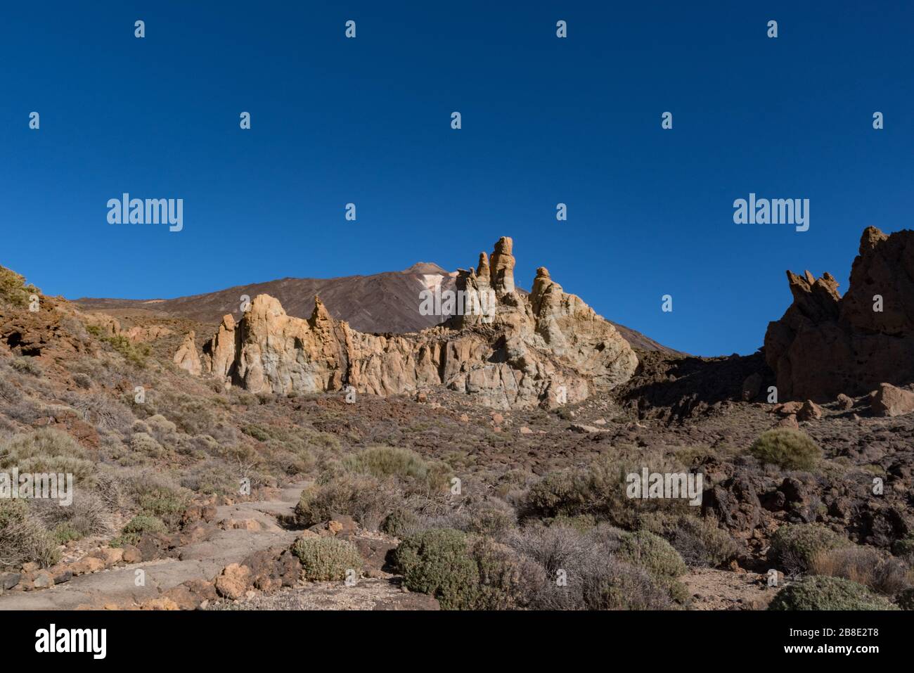 Blick auf die einzigartige Felsformation Roques de García mit dem berühmten Gipfel des Bergvulkans Pico del Teide im Hintergrund bei Sonnenaufgang, Teide National Park, Stockfoto