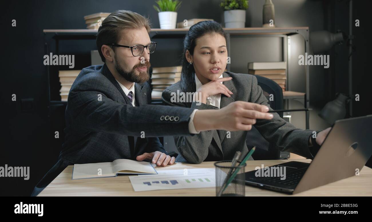 Kollegen, die über die Arbeit an einem Laptop sprechen Stockfoto