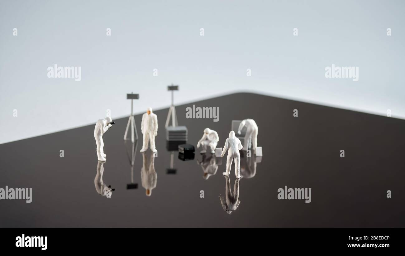Miniatur weiße Wissenschaftler untersuchen glatte Oberfläche Stockfoto