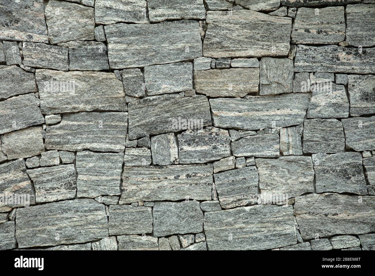 Hintergrund einer zufälligen grauen Steinwand. Stockfoto