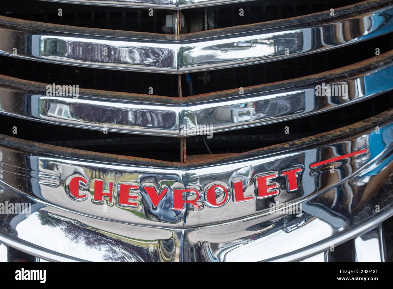 Chrom-Chevrolet-Kühlergrill auf einem Trödelwagen in einem Schrottplatz Stockfoto