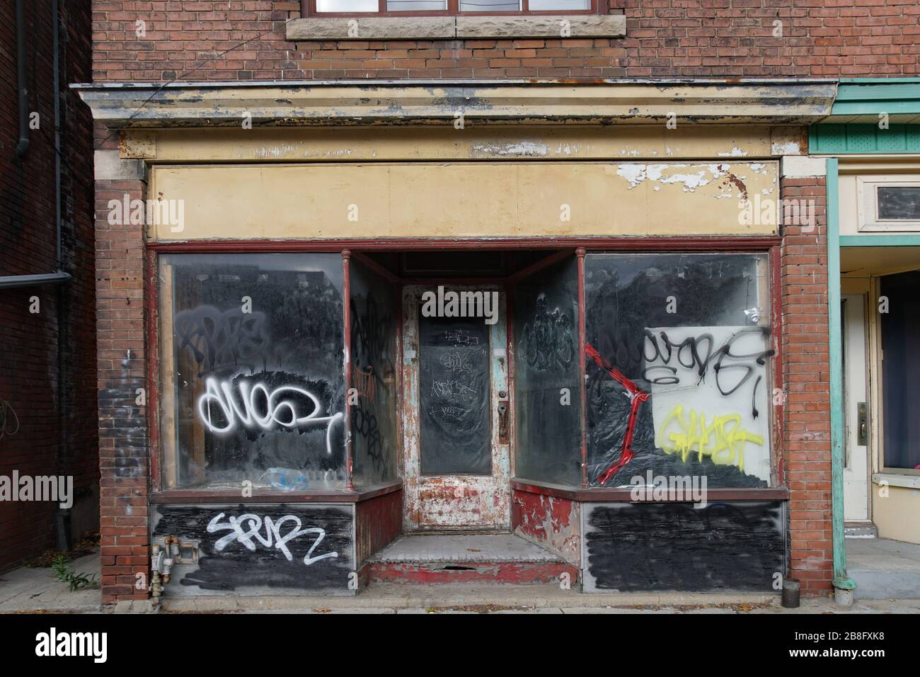 Verderbtes altes Schaufenster mit Graffiti Stockfoto