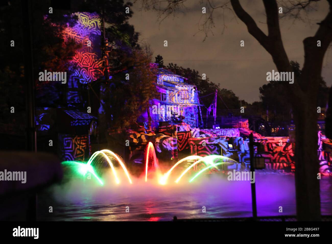 Farbige Beleuchtung auf dem Wasser im Freizeitpark bei Nacht und andere Objekte für Unterhaltung zahlender Gäste in Anaheim California Farbkonzepte Hintergründe Stockfoto