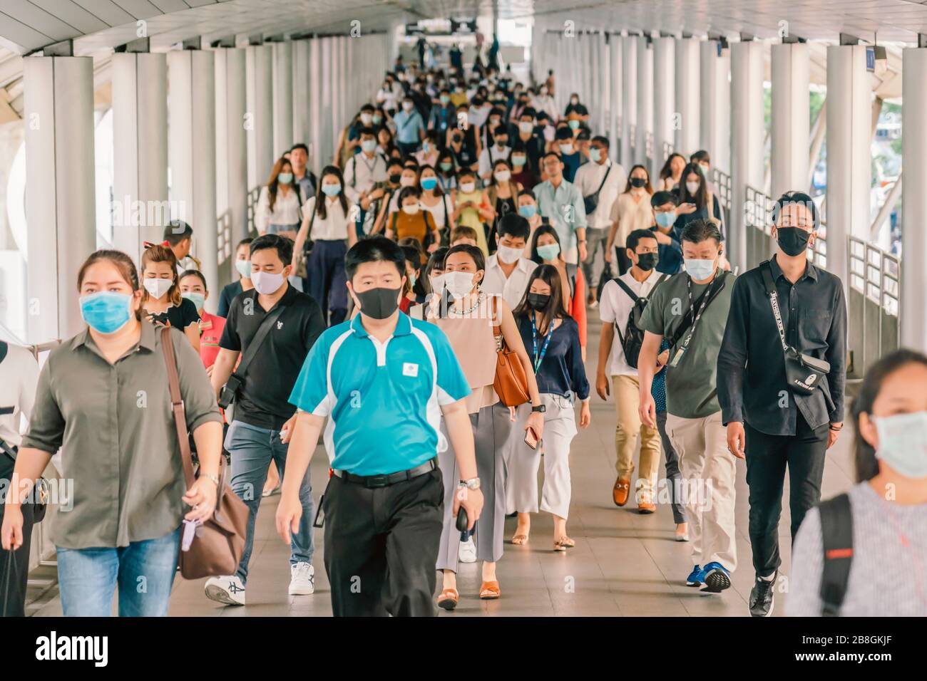 BANGKOK, THAILAND - MAR 2020: Menschenmenge von nicht erkennbaren Geschäftsleuten, die eine chirurgische Maske tragen, um einen Ausbruch von Coronavirus in der Hauptverkehrszeit zu verhindern Stockfoto