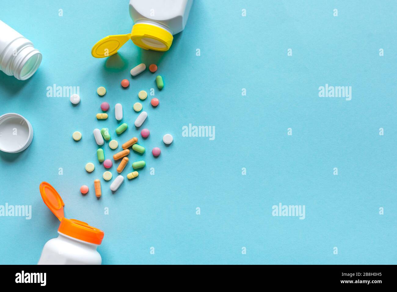 Flaschen mit verschiedenen bunten Pillen, Tabletten auf blauem Hintergrund, Draufsicht, Kopierraum. Vitamine und Generika, Pharmazie und Medizin Konzept. Stockfoto