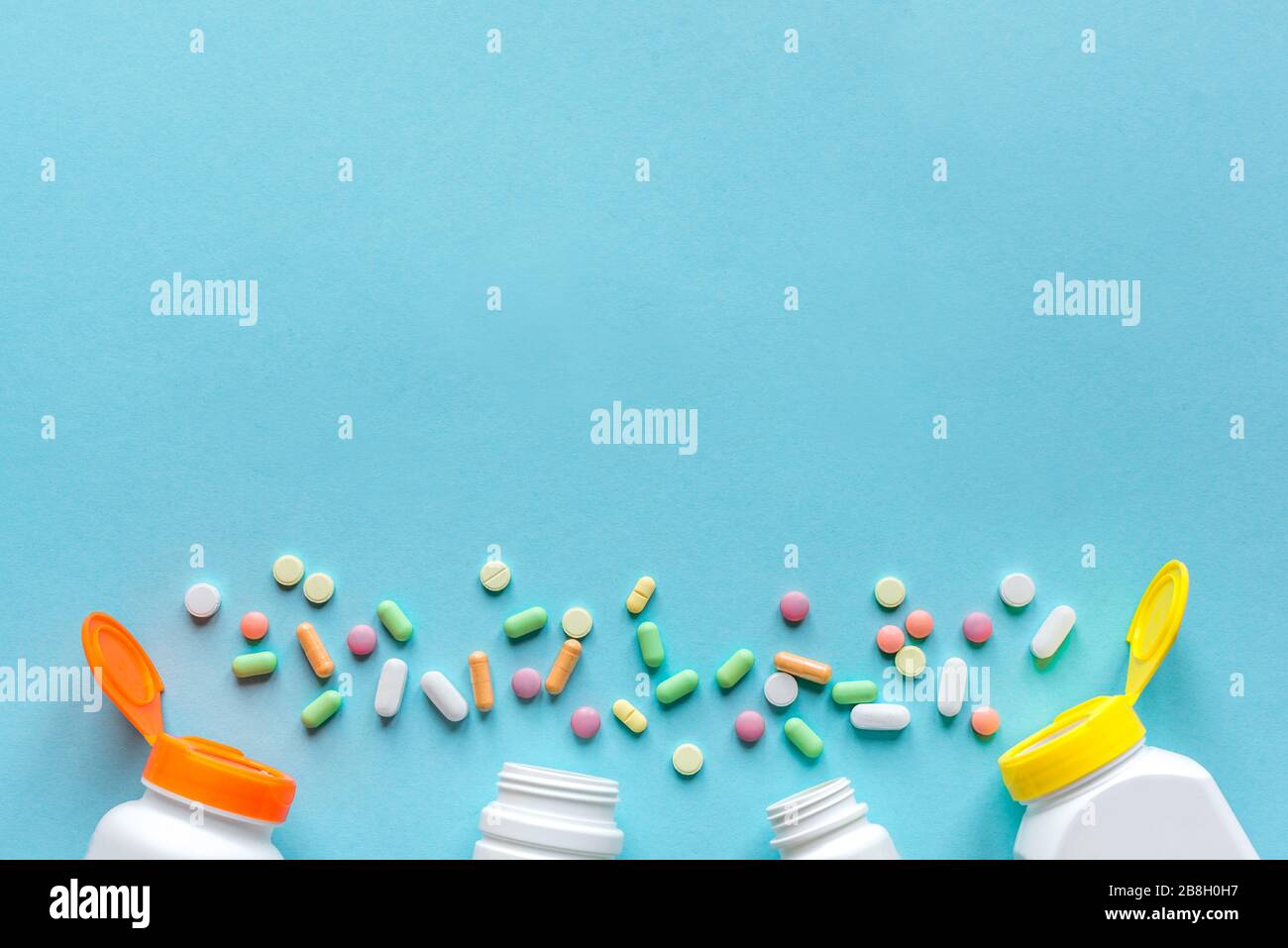 Flaschen mit verschiedenen bunten Pillen, Tabletten auf blauem Hintergrund, Draufsicht, Kopierraum. Vitamine und Generika, Pharmazie und Medizin Konzept. Stockfoto
