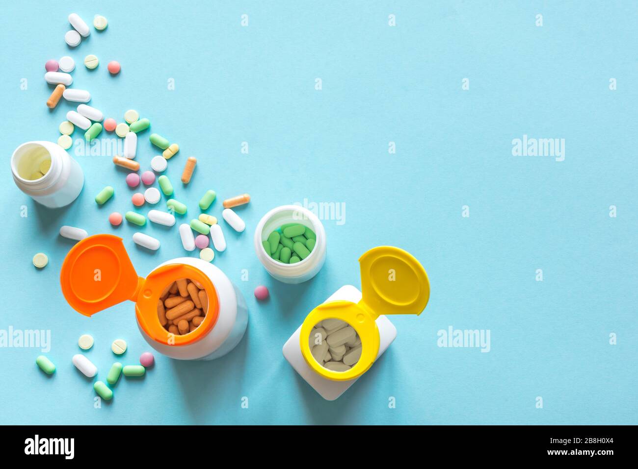Verschiedene bunte Pillen und Kapseln auf blauem Hintergrund, Draufsicht, Kopierbereich. Medizinisches Konzept. Verschiedene Generika und Vitamine. Stockfoto