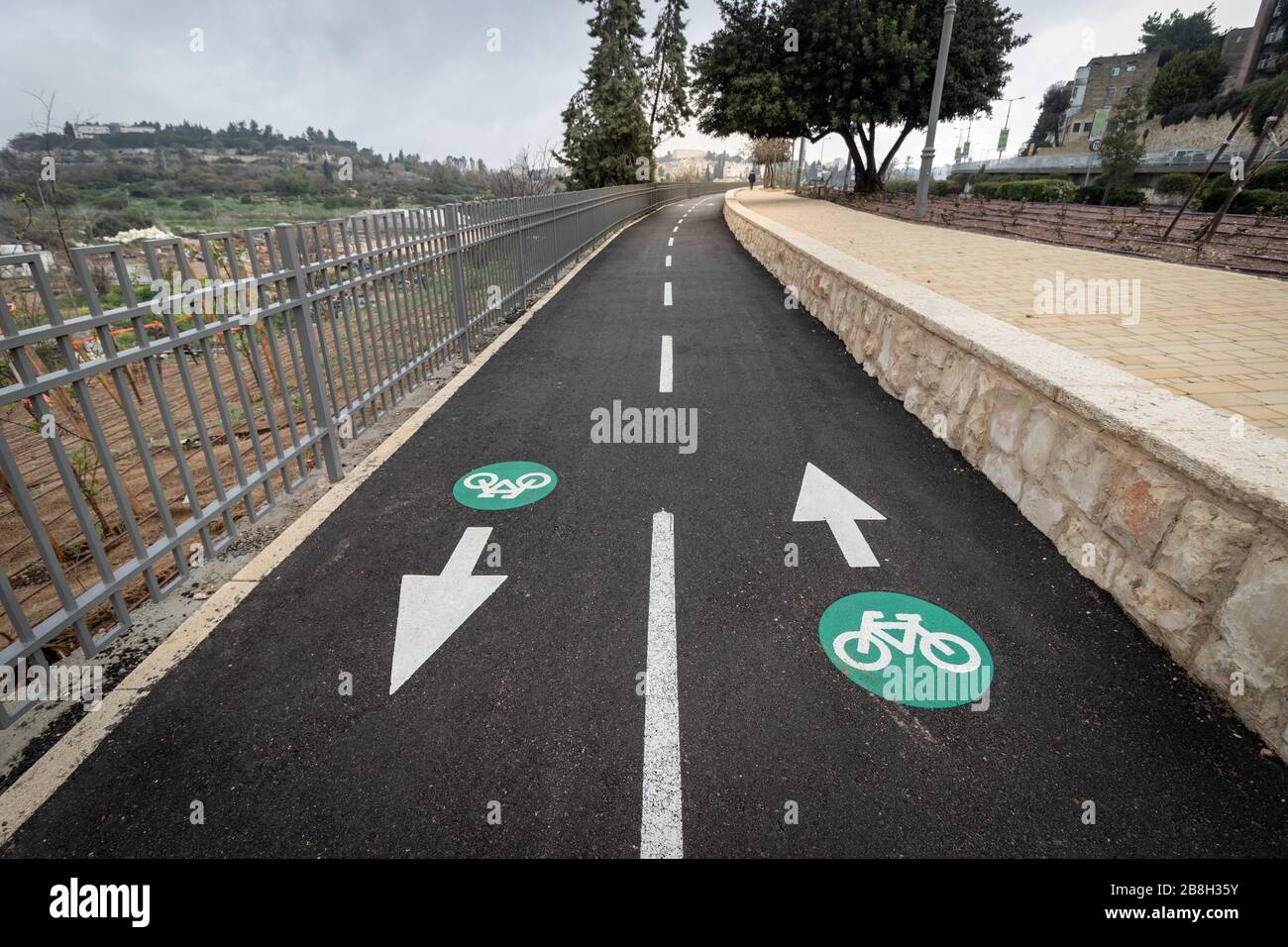 Grün-weiße Farbe auf Asphalt, um einen Radweg zu markieren, Weitwinkelfotografie. Stockfoto