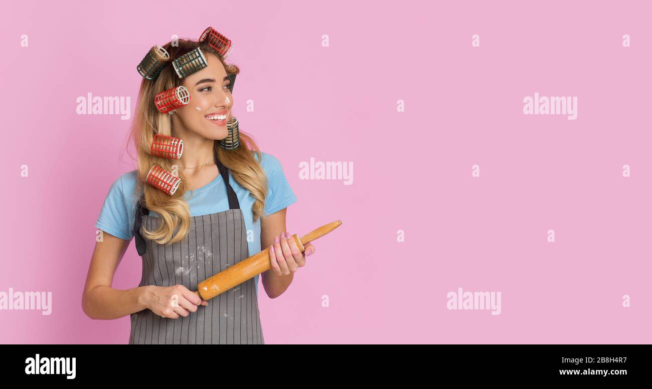 Positive energetische Hausfrau mit Rollstift, die beiseite schaut Stockfoto