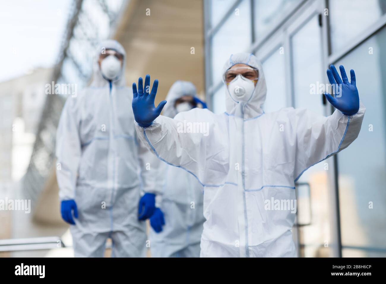 Mann im Schutzanzug zum Anhalten der Menschenmenge Stockfoto