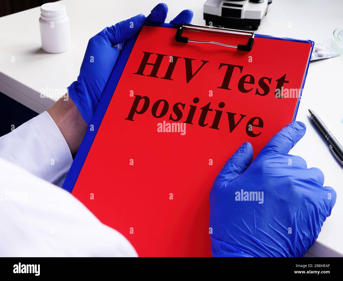 Doktor hält HIV Test positiv und Zwischenablage. HIV/AIDS-Konzept. Stockfoto