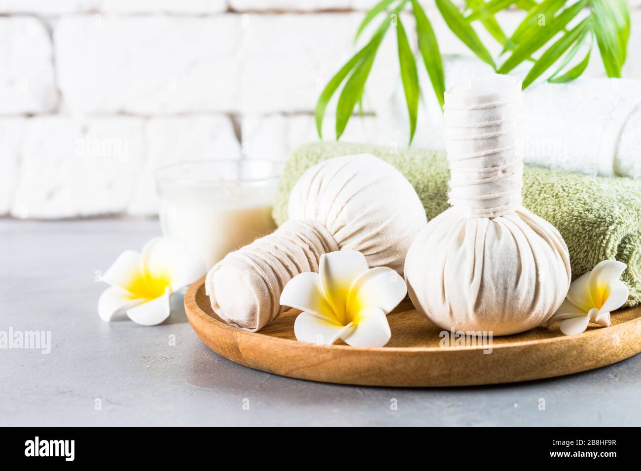 Thai-Massage, die Bälle, Handtücher und Blumen zusammendrückt. Stockfoto