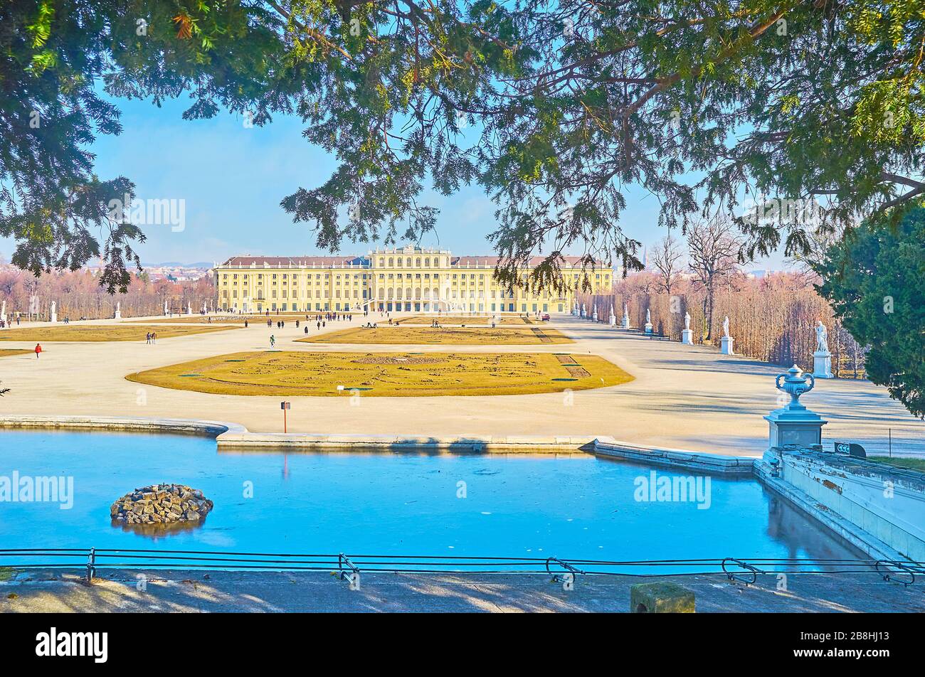 WIEN, ÖSTERREICH - 19. FEBRUAR 2019: Sehen Sie das Schloss Schönbrunn, den Garten (Schlosspark, Bundesgarten) und einen Teich des Neptun Brunnens, am 19. Februar in Stockfoto