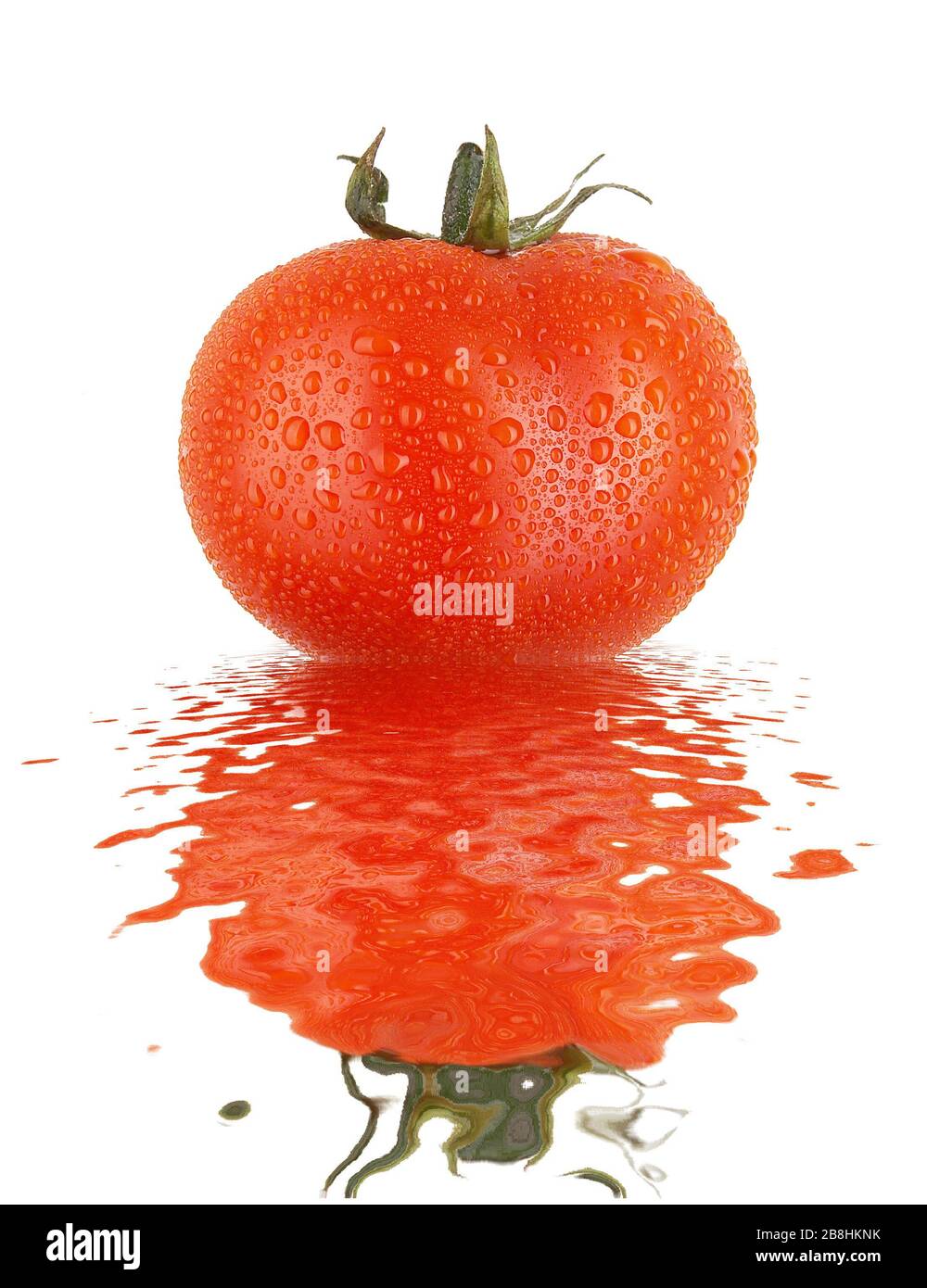 Frische Tomate mit Tropfen und Verzicht auf glatte Wasseroberfläche Stockfoto