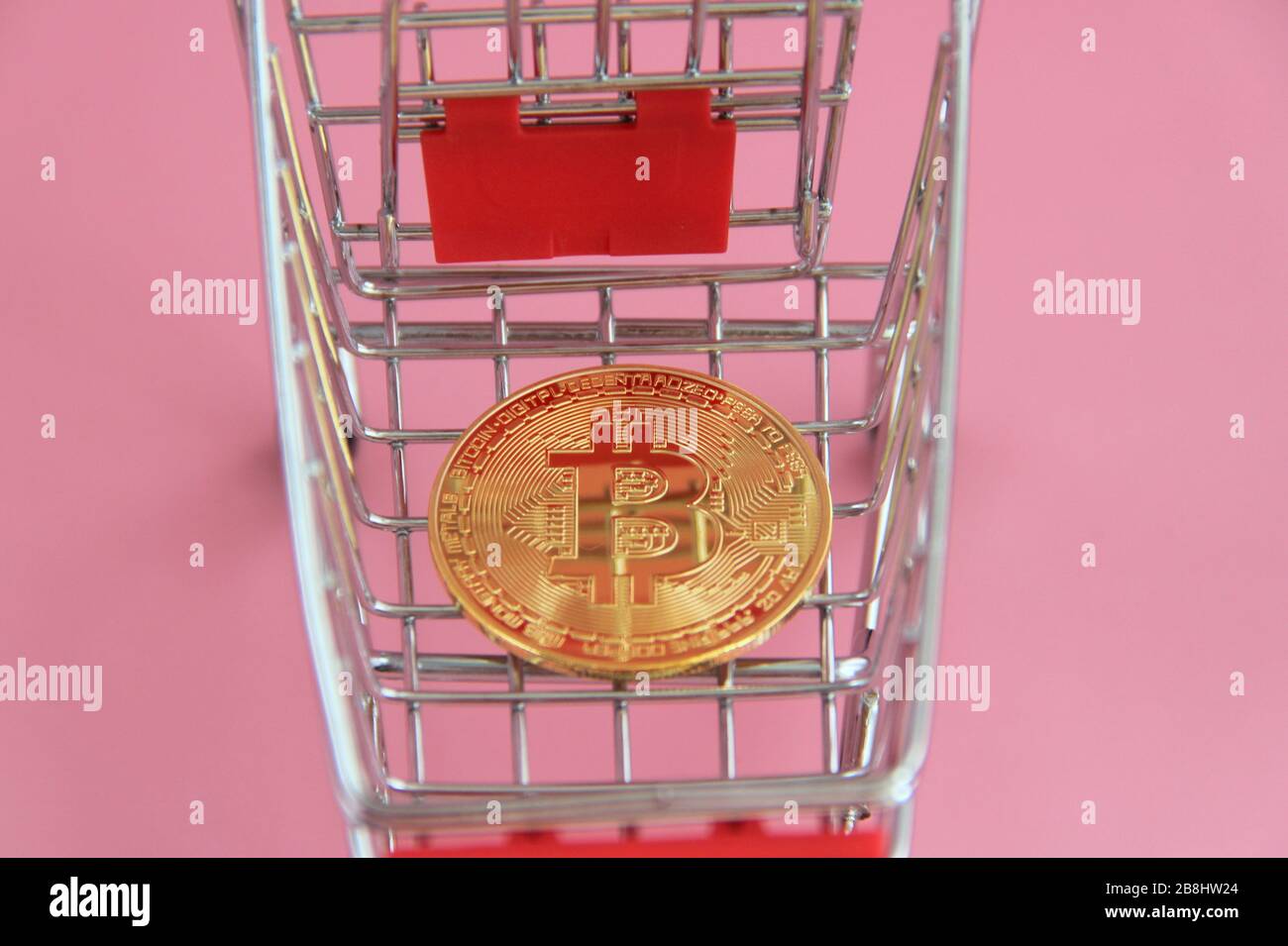 Goldmünze mit dem Bitcoin-Bild liegt im Warenkorb. Stockfoto