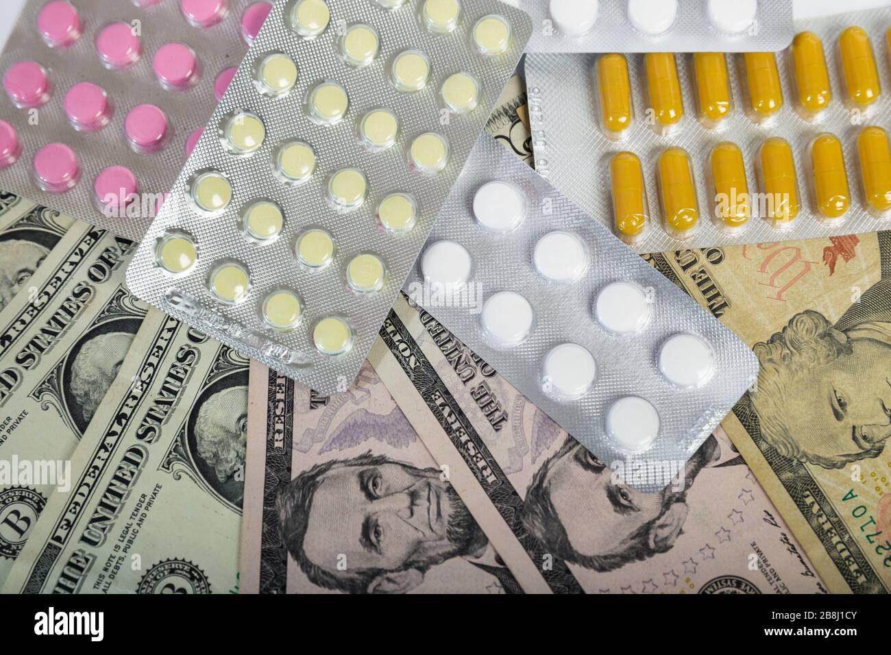 Pillen in Blisterpackungen auf Dollarscheinen. Teures Medizinkonzept Stockfoto