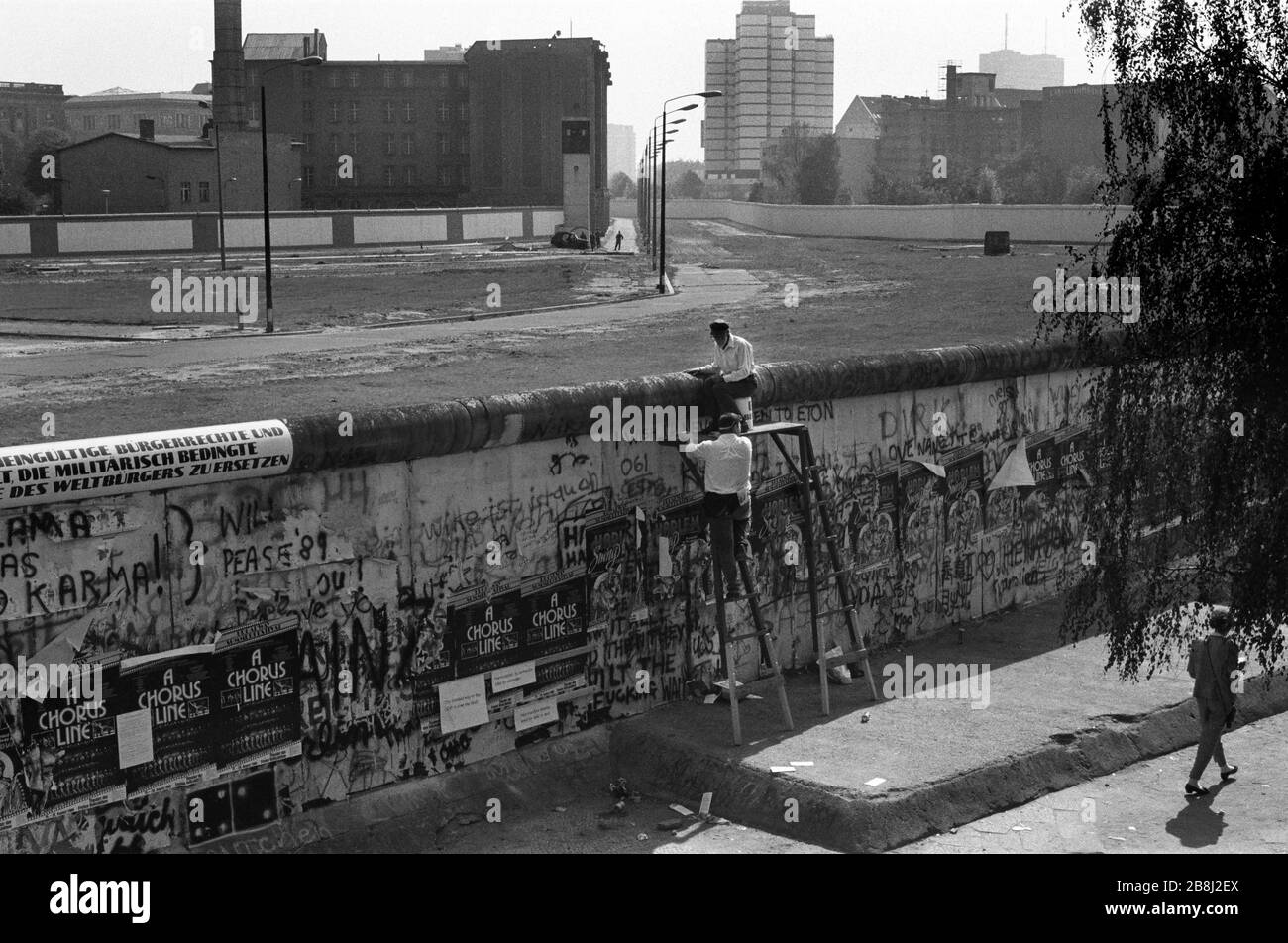 Zwei Männer, die während eines Protestes an einem Abschnitt der Mauer am Brandenburger Tor, West-Berlin, die Berliner Mauer skalieren. Die Berliner Mauer war eine von der Deutschen Demokratischen Republik (DDR, Ostdeutschland) am 13. August 1961 errichtete Barriere, die West-Berlin von der umliegenden DDR und von Ost-Berlin völlig abgrenzte. Die Mauer wurde am 9. November 1989 die freie Personenbewegung von Ost nach West erlaubt. Stockfoto