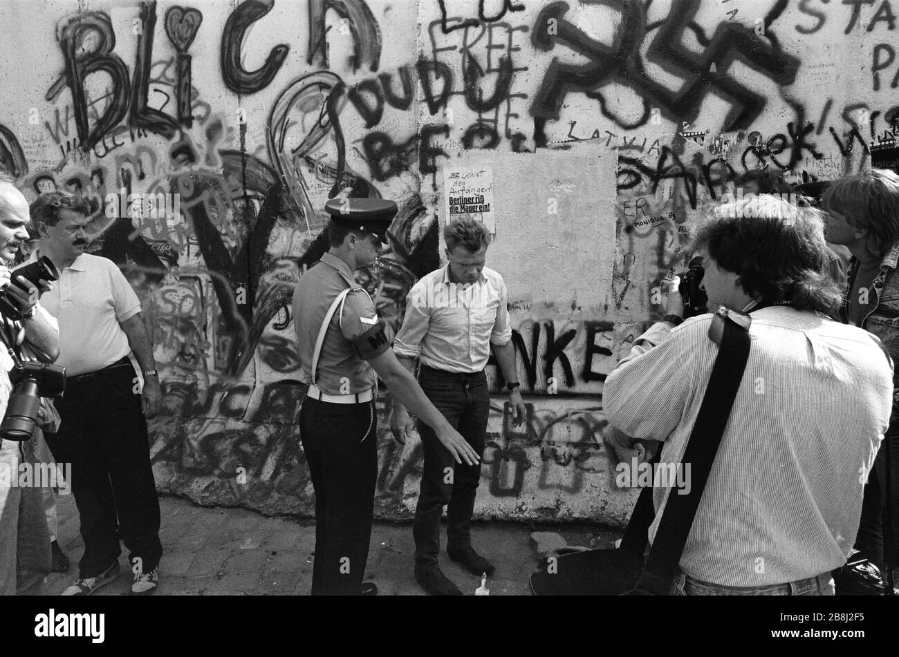 Die Militärpolizei greift während eines Protestes an einem Abschnitt der Berliner Mauer am Brandenburger Tor, West-Berlin, ein. Die Berliner Mauer war eine von der Deutschen Demokratischen Republik (DDR, Ostdeutschland) am 13. August 1961 errichtete Barriere, die West-Berlin von der umliegenden DDR und von Ost-Berlin völlig abgrenzte. Die Mauer wurde am 9. November 1989 die freie Personenbewegung von Ost nach West erlaubt. Stockfoto