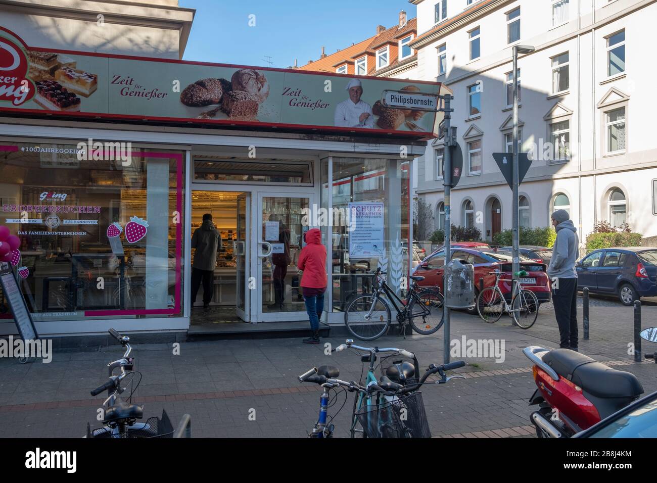 Warteschlange vor Hannovers Bäckerei Göing mit Sicherheitsabstand wegen Korona-Pandemie. Im Anmeldefenster werden Sicherheitsmaßnahmen angezeigt. Stockfoto