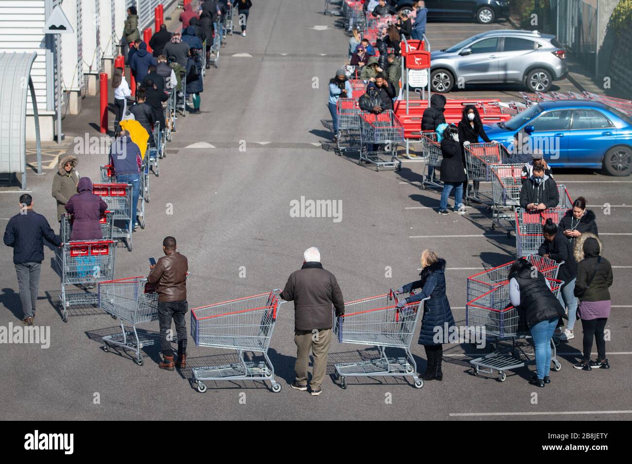 Käufer warten außerhalb einer Filiale von Costco, in Croydon, im Süden Londons, Am Wochenende, nachdem Premierminister Boris Johnson Kneipen und Restaurants im ganzen Land geschlossen hatte, kündigte die Regierung beispiellose Maßnahmen an, um die Löhne der Arbeiter zu decken, die ansonsten aufgrund des Ausbruchs des Coronavirus ihren Arbeitsplatz verlieren würden. Stockfoto