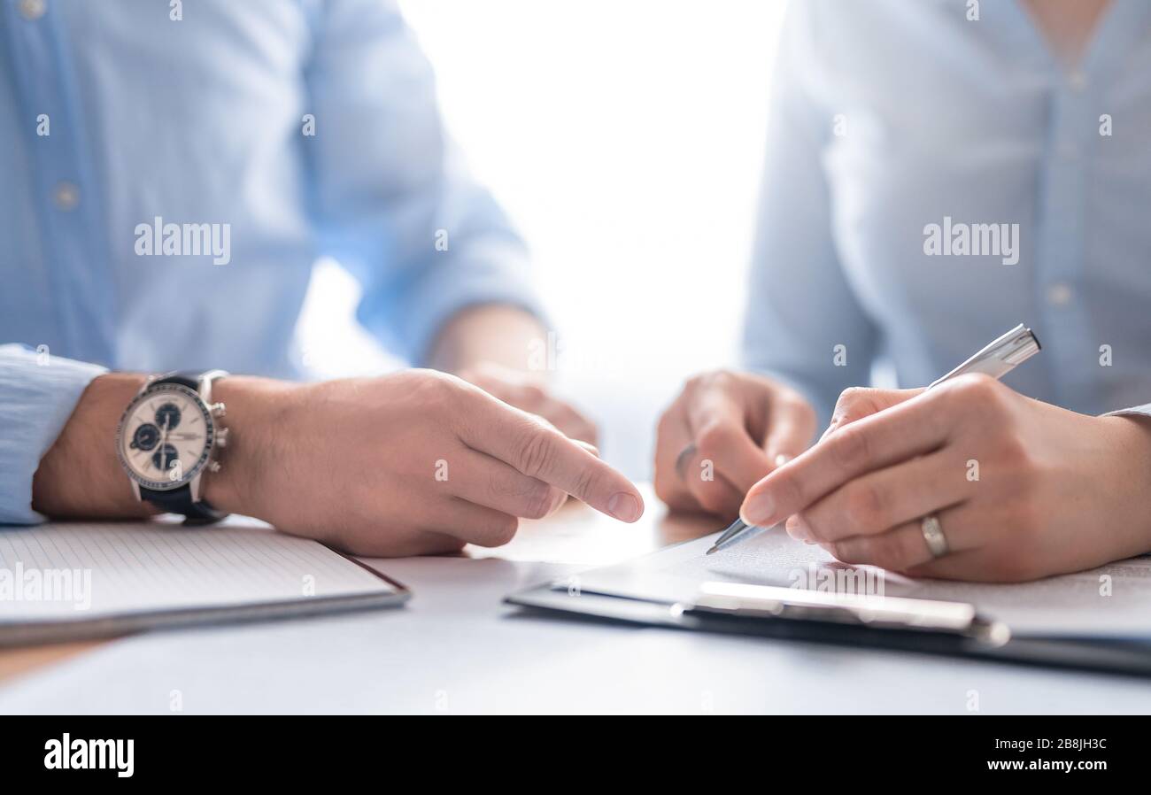 Geschäftsleute, die einen Vertrag aushandeln. Menschliche Hände, die mit Dokumenten am Schreibtisch arbeiten und einen Vertrag unterzeichnen. Stockfoto