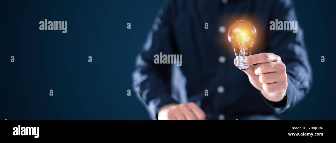 Kreative neue Idee. Innovation, Brainstorming, Inspiration und Lösungskonzepte. Der Mann hält die Glühlampe. Hintergrund des Kopierraums. Stockfoto