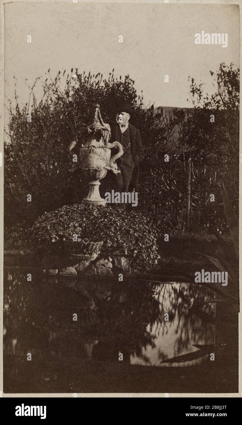 Victor Hugo im Garten des Hauses Hauteville, hinter dem Brunnen mit Schlangen stehend Victor Hugo dans le jardin de Hauteville House, debout derrière la fontaine aux Serpents. Photographie d'Arsène Garnier (1822-1900). Epreuve sur Papier albuminé. Im Jahre 1868. Paris, Maison de Victor Hugo, Hauteville House. Stockfoto