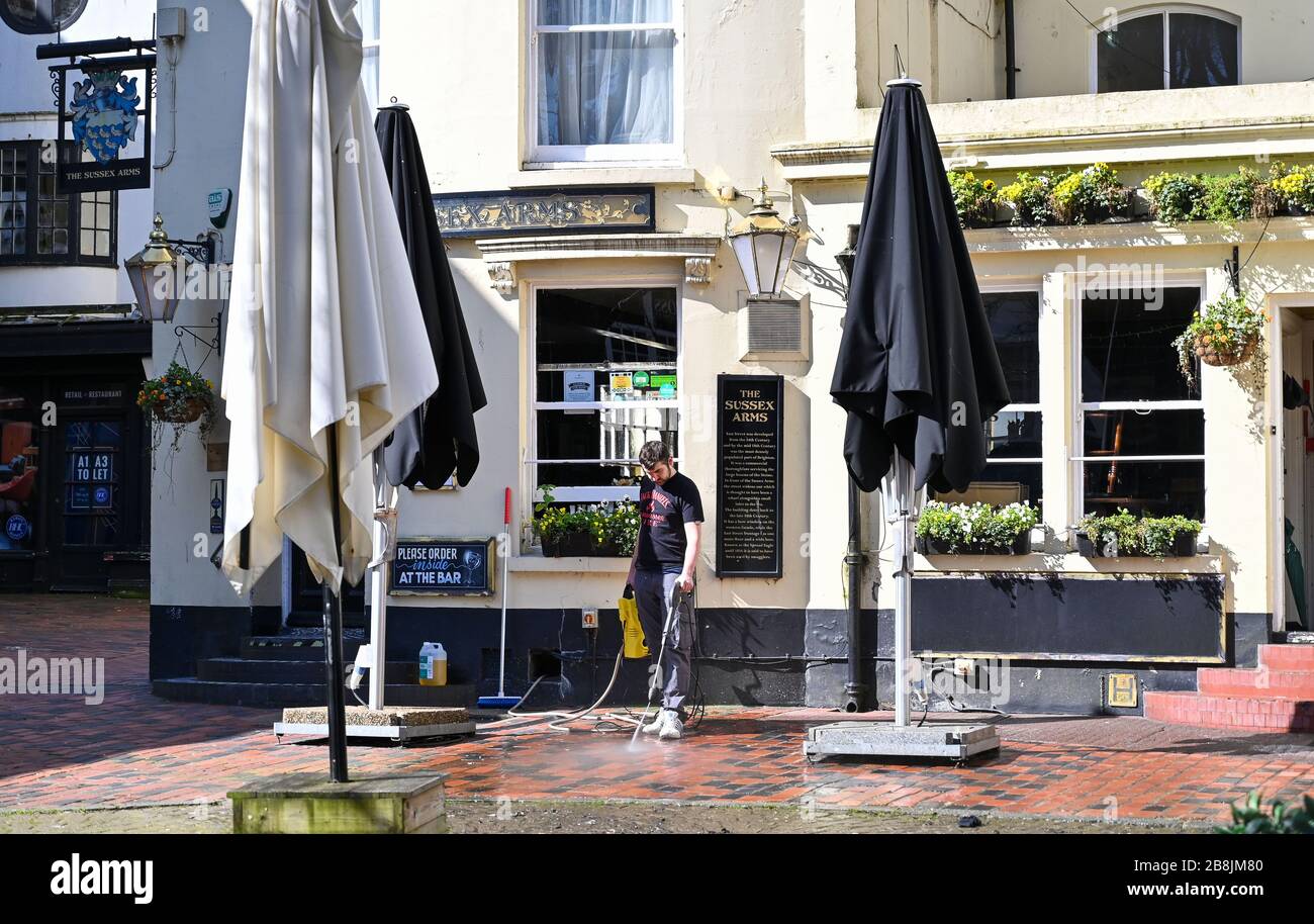 Brighton UK 22. März 2020 - die Reinigung geht vor dem geschlossenen Sussex Arms Pub in Brighton während der Coronavirus COVID-19-Pandemie-Krise weiter. Kredit: Simon Dack / Alamy Live News Stockfoto