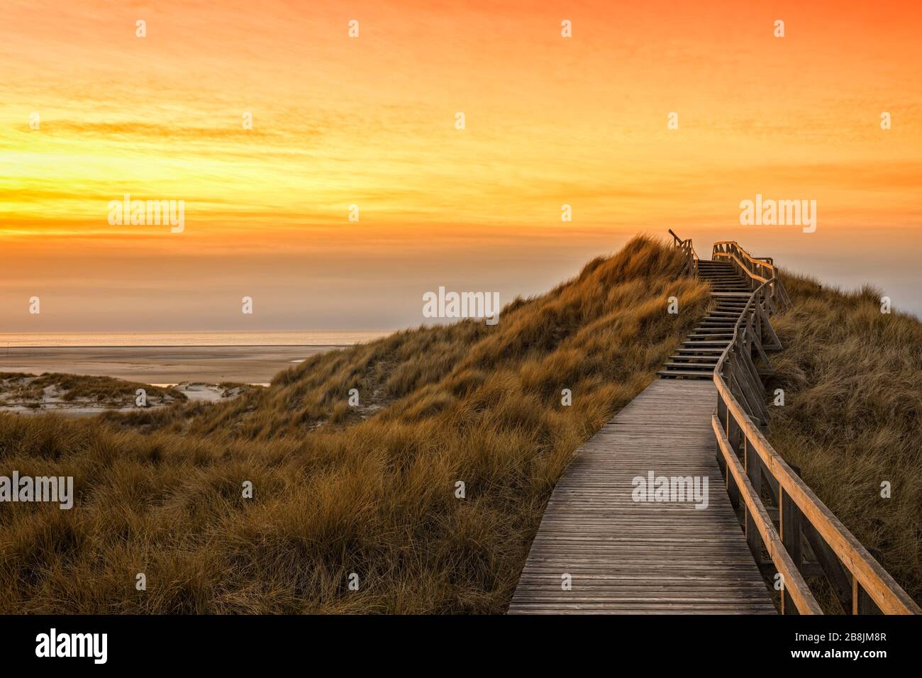Holzfußpfad und Treppe, die die Dünen zum Strand von Norddorf auf der deutschen Nordseeinsel Amrum bei lebendiger Sonne überqueren Stockfoto