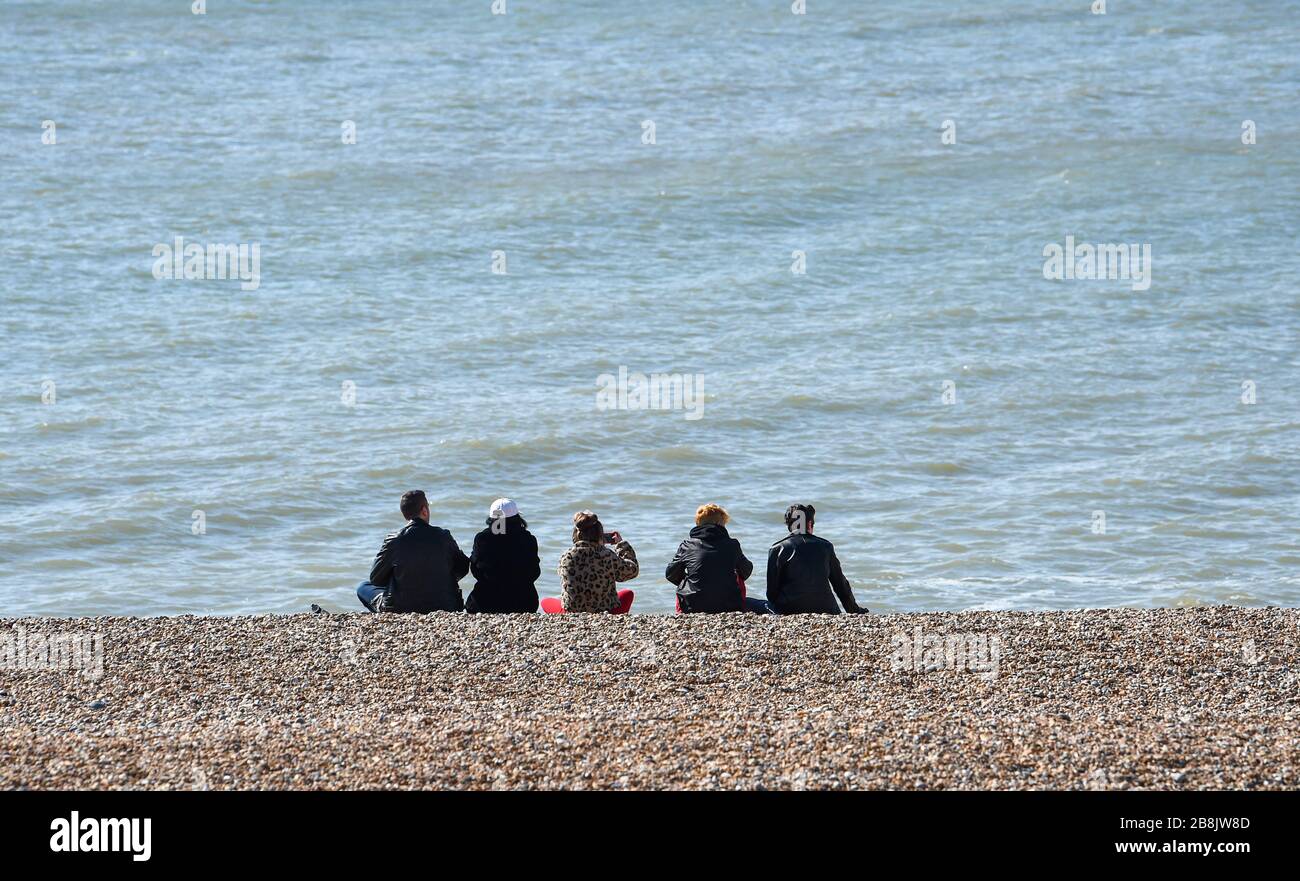 Brighton UK 22. März 2020 - Besucher ignorieren die sozialen Distanzierungsmaßnahmen, da sie heute am Strand von Brighton einen Sonnenschein im Frühling genießen, der heute Morgen während der Coronavirus COVID-19-Pandemie-Krise spärlich aussieht. Kredit: Simon Dack / Alamy Live News Stockfoto