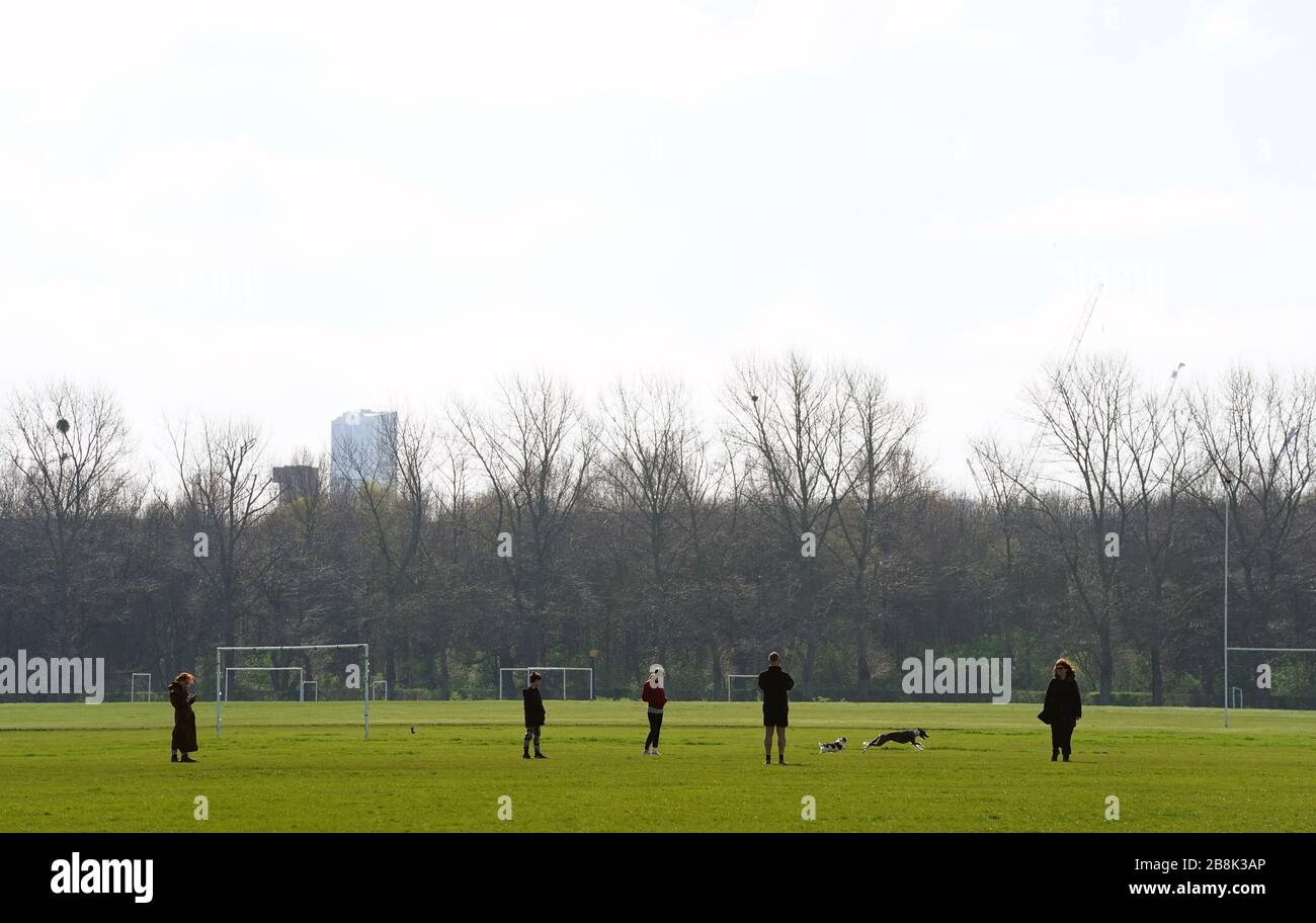 Hundegänger bei Hackney Marshes in London, da der gesamte Breitenfußball in England auf absehbare Zeit verschoben bleibt. Stockfoto