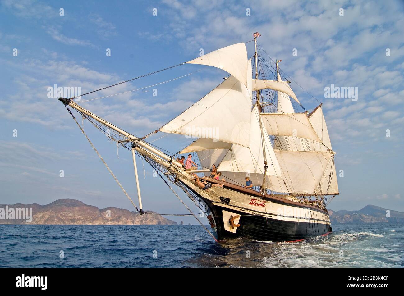 Altes Holzschiff, das in der Abendsonne zwischen äolischen Inseln in italien segelt Stockfoto