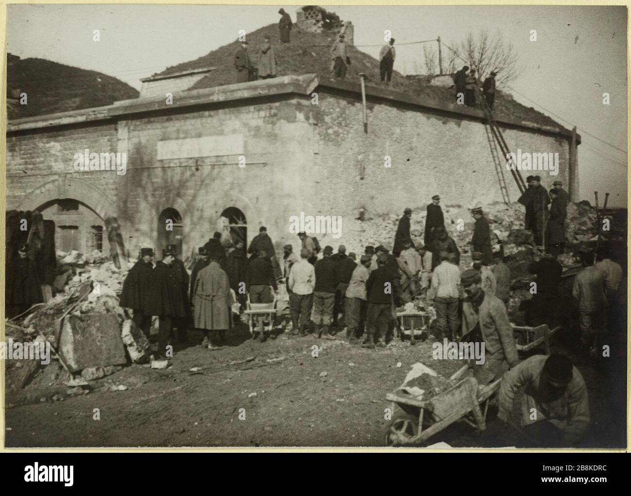 Explosionshöhe des Double-Crown St Denis. Der Abstand funktioniert. Entfernung von Trümmern nach der Explosion des Forts der Doppelkrone in Munitionsdepot geändert, Saint-Denis, 4. März 1916 Anonyme. Explosion au fort de la Double-couronne à St Denis. Travaux de déblaement. Déblaiement des débris après l'explosion du fort de la Double-couronne tranformé en dépôt de munition, Saint-Denis, le 04 mars, 1916. Tirage au gélatino-bromure d'argent. 04 mars 1916-04 mars 1910. Paris, musée Carnavalet. Stockfoto