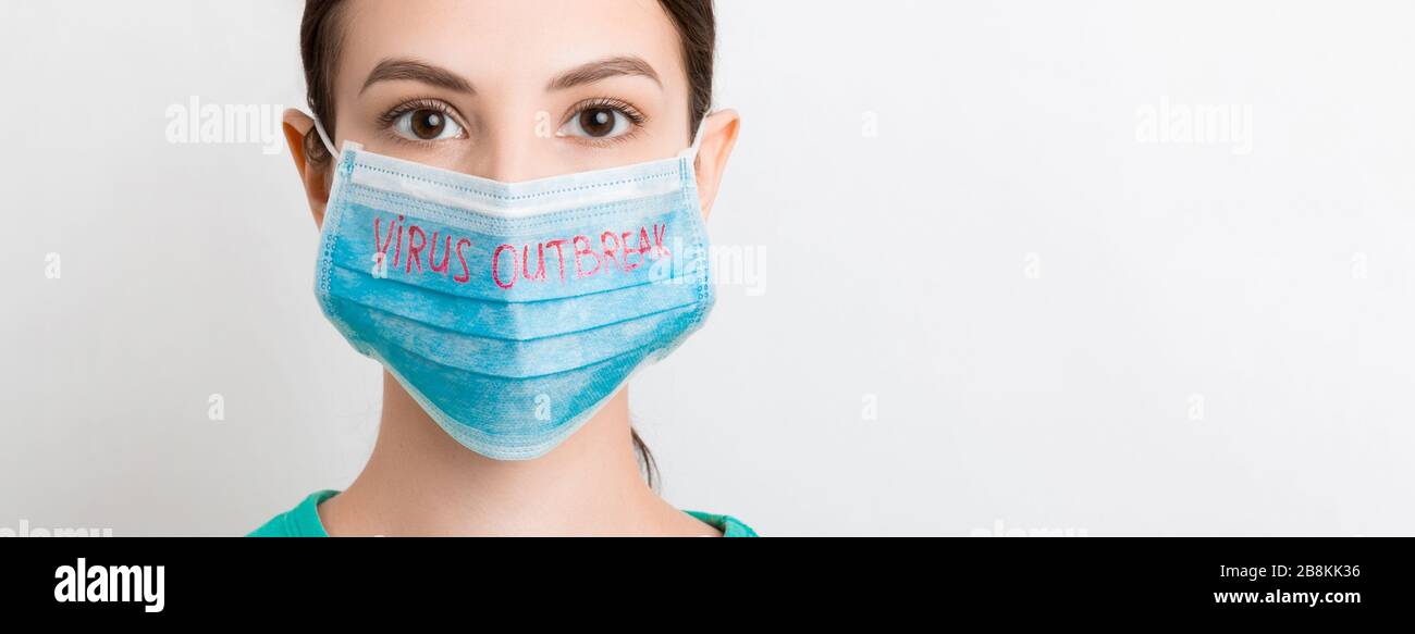 Porträt einer hübschen Frau, die eine medizinische Maske mit einem Virus-Outbreak-Text auf weißem Hintergrund trägt. Coronavirus Konzept. Atemschutz. Stockfoto