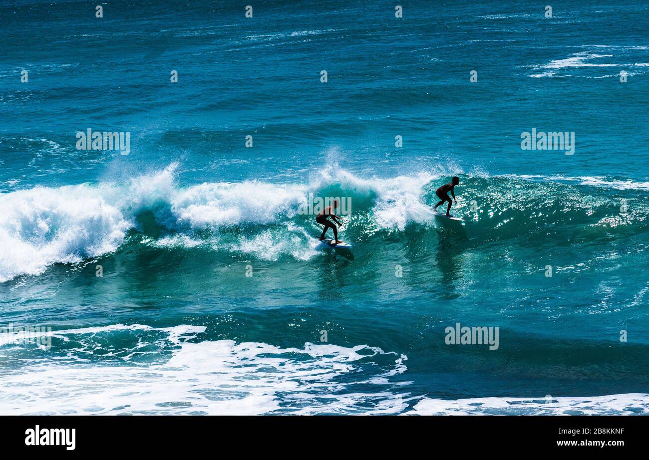 Zwei professionelle Surfer, die in Uluwatu, Indonesien, die großen Wellen schlagen. Stockfoto