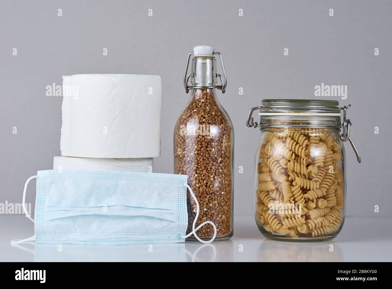 Verbraucher kaufen Panik über Coronavirus Kovid-19-Konzept. Toilettenpapierrolle, Pasta, Buchweizen und Arzneischutzmaske. Die Leute sind auf der Strumpfung Stockfoto