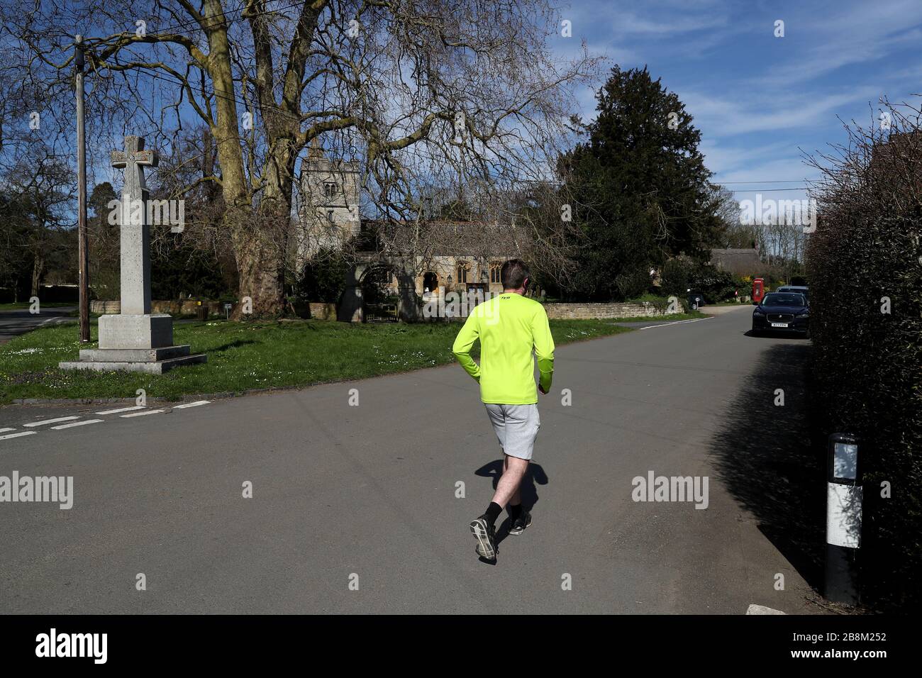 Ein Mann joggt in der Nähe von St. James, der großen Kirche in Birlingham, Worcestershire, da Kirchen in ganz Großbritannien Sonntagsgottesdienste für Massenpublikum über das Internet heute inmitten der Bemühungen, Covid-19 zu bekämpfen, erbracht haben. Stockfoto