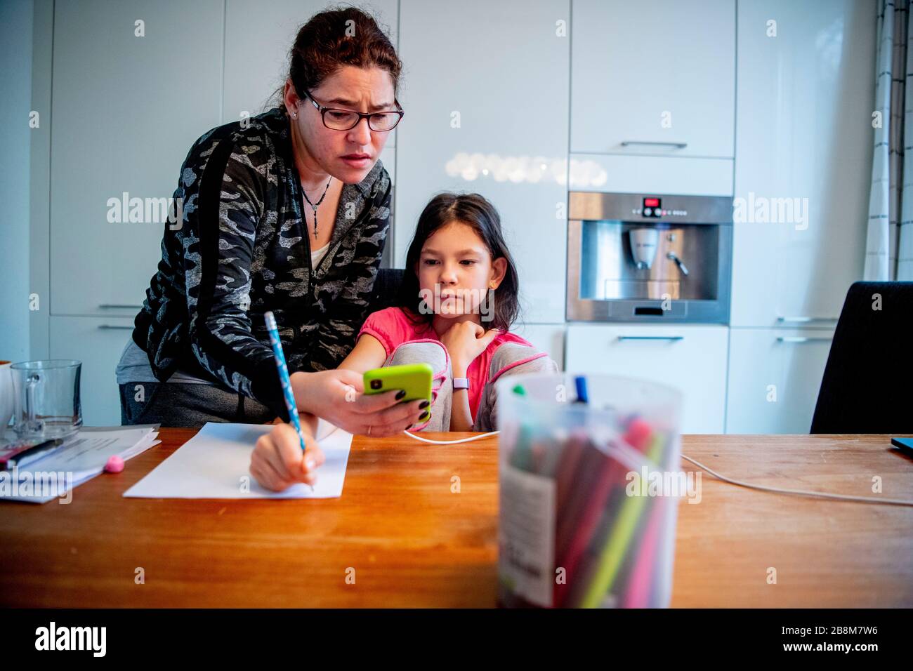 Ein 9 Jahre altes Kind bekommt mit der Assistentin ihrer Mutter zu Hause digitalen Schulunterricht. Die niederländische Regierung hat alle Schulen bis auf weiteres geschlossen, um die Verbreitung des COVID-19 Coronavirus zu kontrollieren. Die Schüler sollen mit digitalen Mitteln wie Laptops, digitalen Tablets oder Mobiltelefonen zu Hause geschult werden. Stockfoto