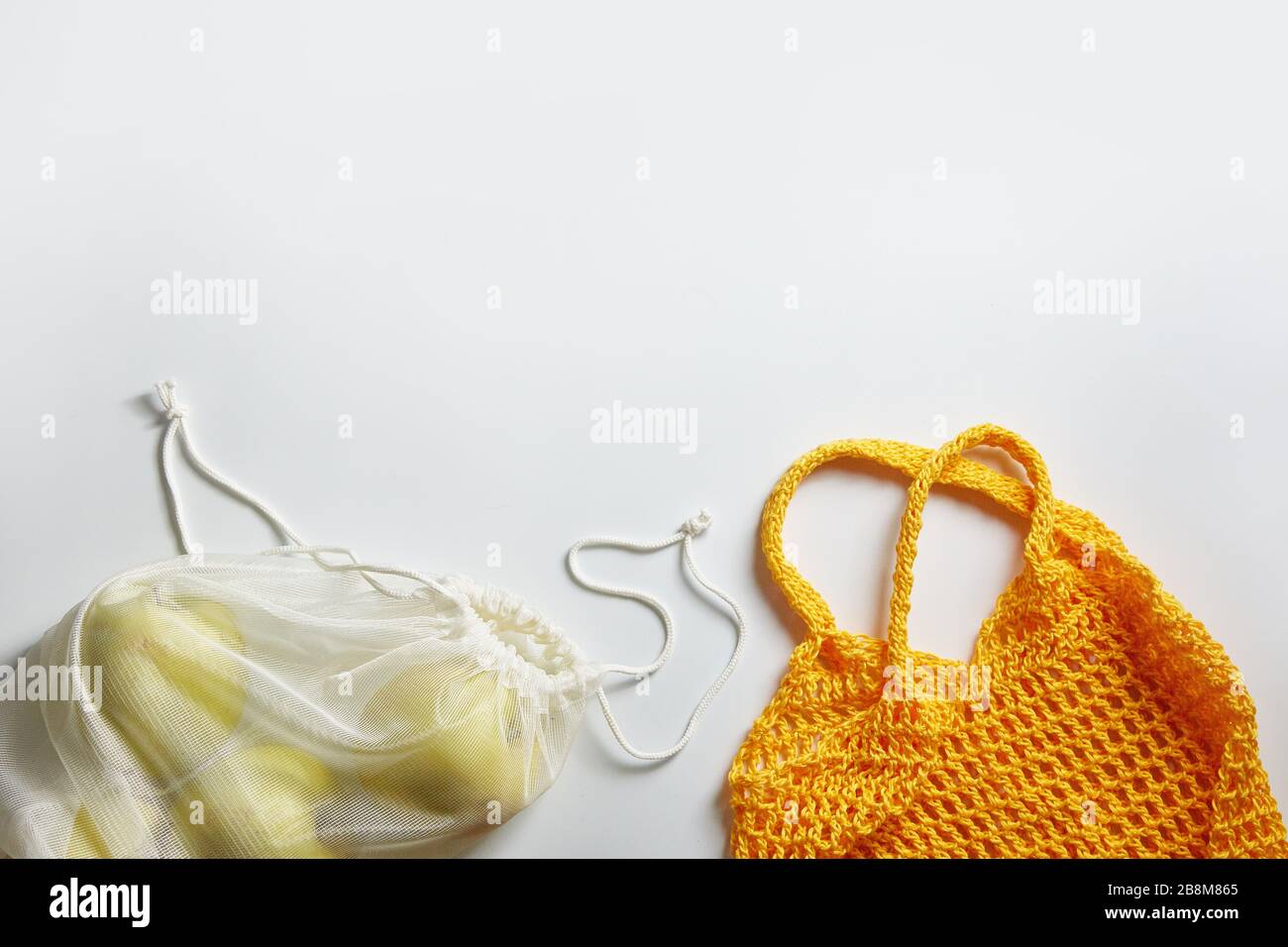 Ökologische Obsttasche und Saitenbeutel auf weißem Hintergrund mit Platz für Text. Stockfoto