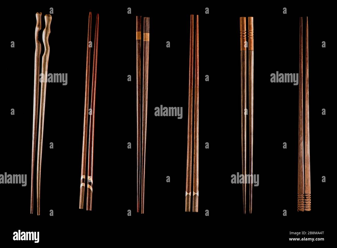 Verschiedene Holzstäbchen vor schwarzem Hintergrund. Asiatische Essgeschirr. Barcode-Darstellung. Stockfoto
