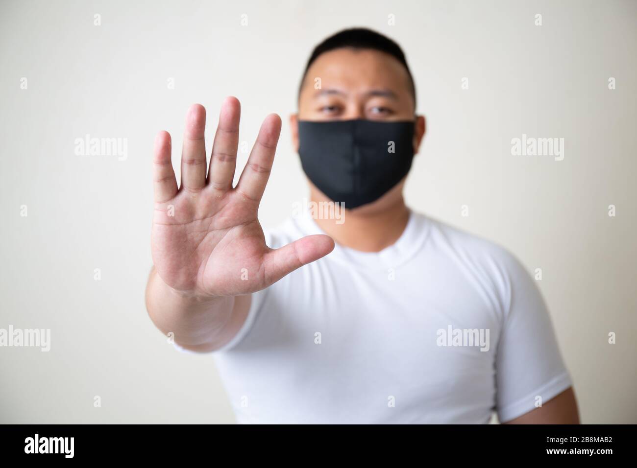 Asiatischer Mann in medizinischer Maske Coronavirus Pandemie-Krankheit auf grauem Hintergrund. COVID-19-Virus vom Ausbruch der Epidemie in China bis hin zum globalen Rezessionskonzept für Stockfoto