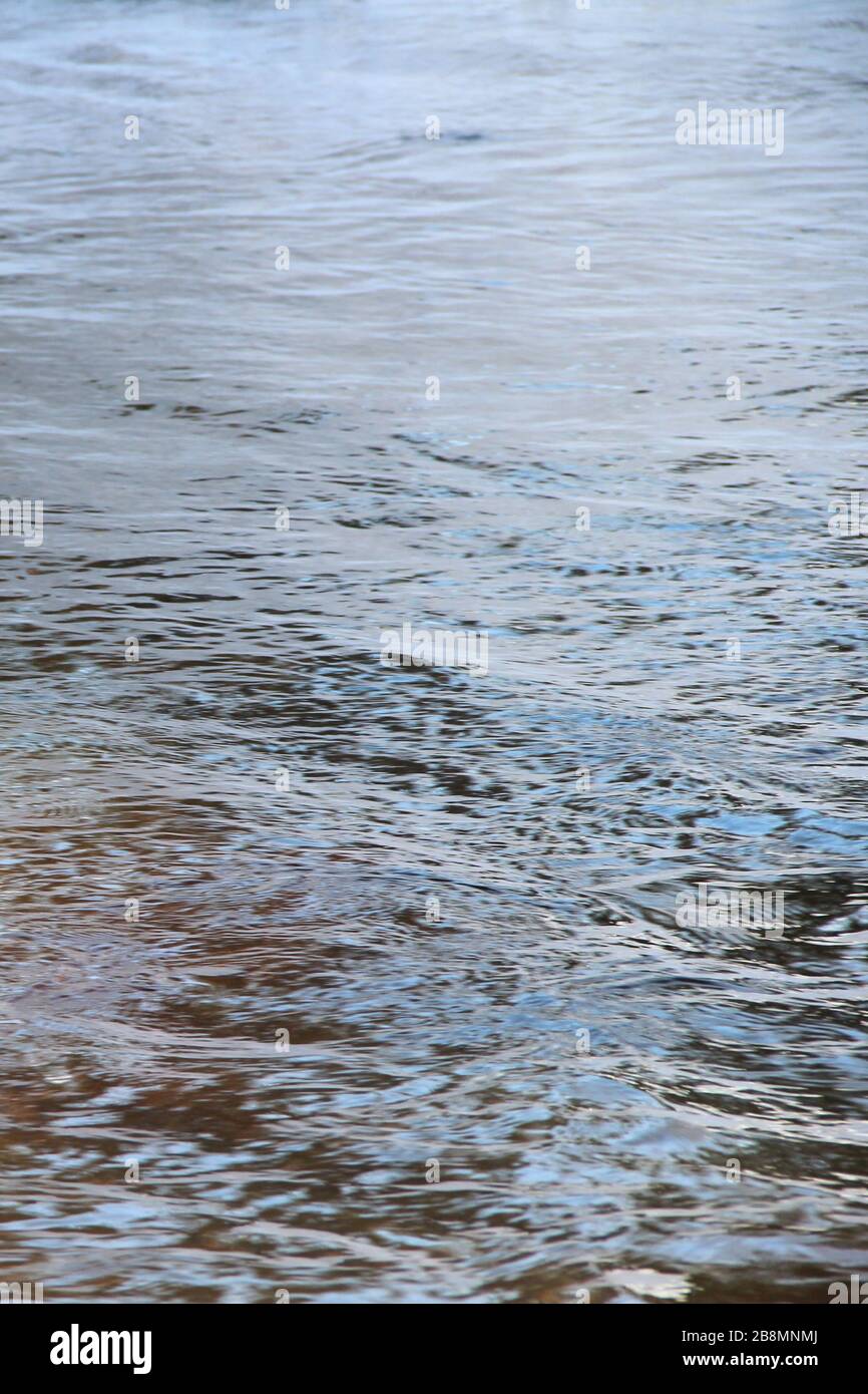 Wasseroberfläche mit Wellen und Lichtblendung. Platz für Text und Design. Stockfoto