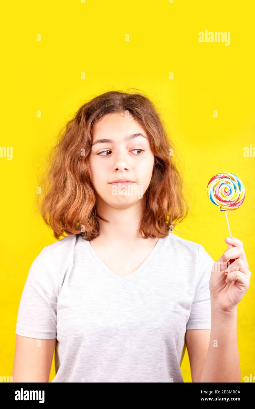 Teenager-Mädchen mit mehrfarbigem runder Lollipop Stockfoto