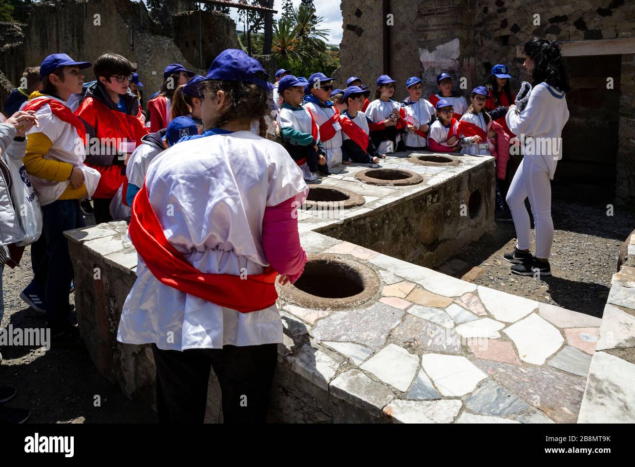 Schulunterricht über ein uraltes römisches Fast-Food-Geschäft, Herculaneum, Kampanien, Italien. Stockfoto
