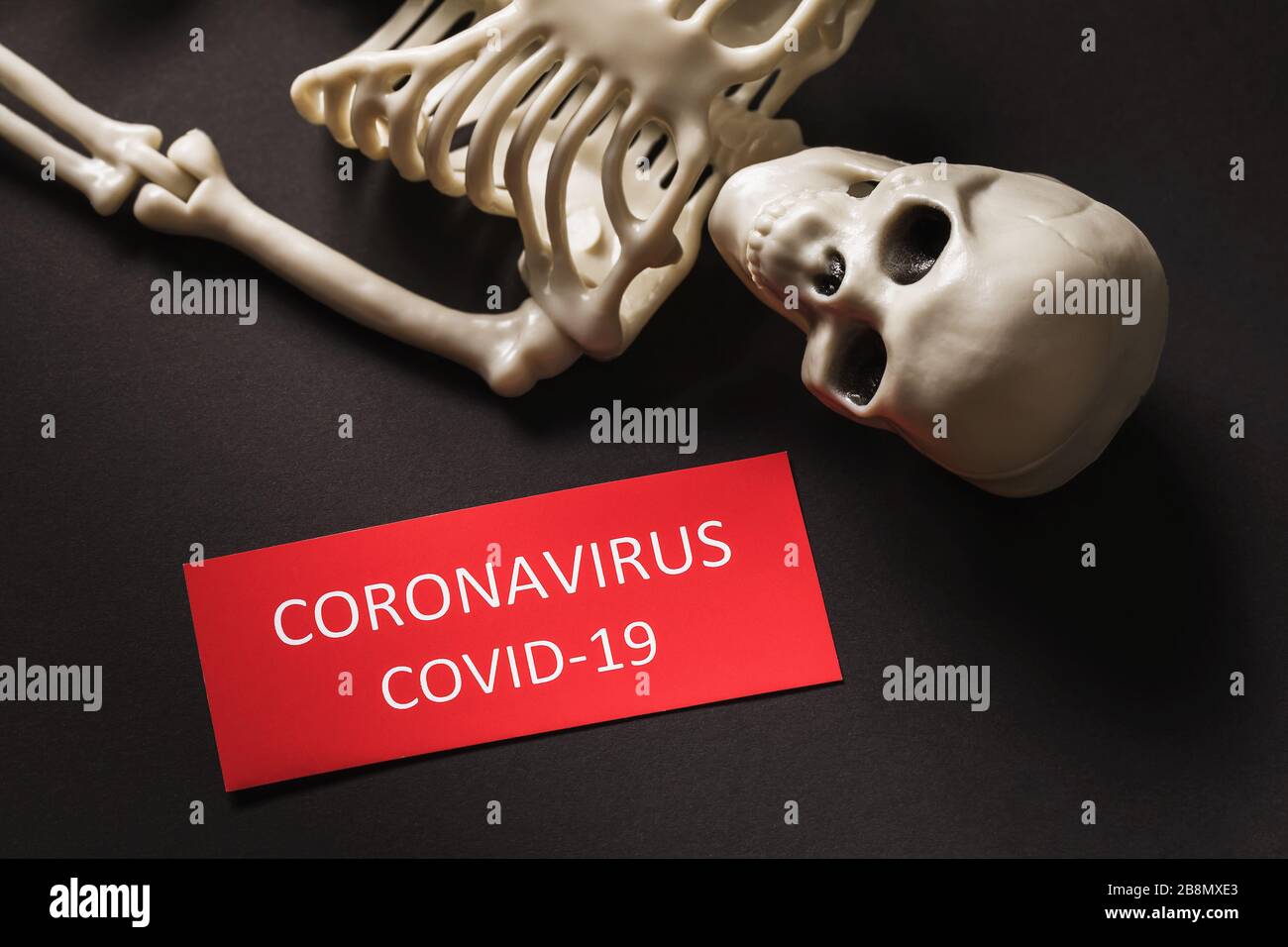 Skelett und Tag mit Text auf schwarzem Hintergrund. Das Konzept der Opfer der Pandemie COVID-19 Stockfoto