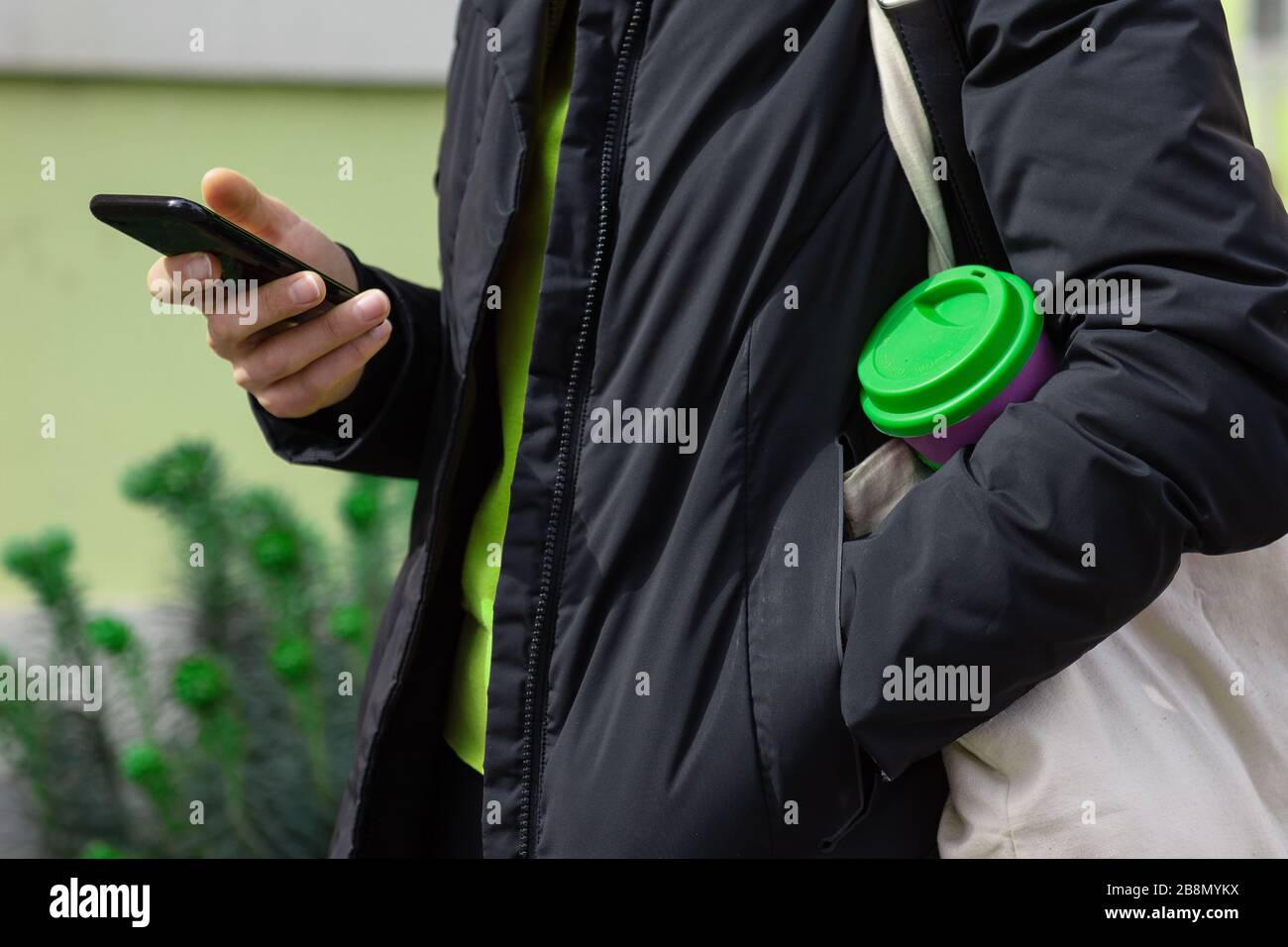 Wiederverwendbarer Kaffeebecher für Frauen im Freien. Nachhaltiges Lifestyle-Konzept. Stockfoto