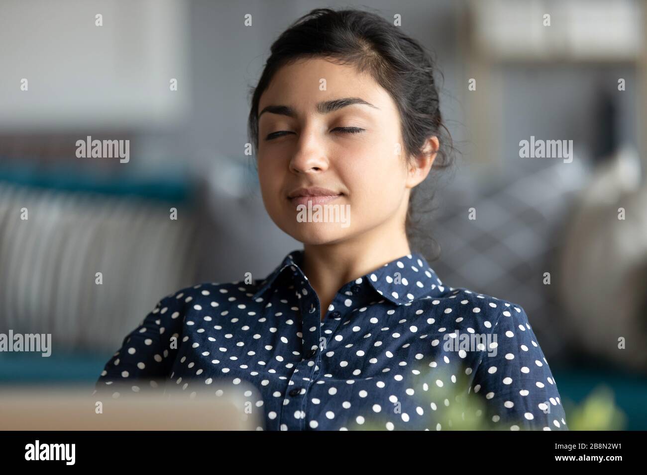 Head Shot friedliche indische Frau entspannend, Tagträumen am Arbeitsplatz Stockfoto