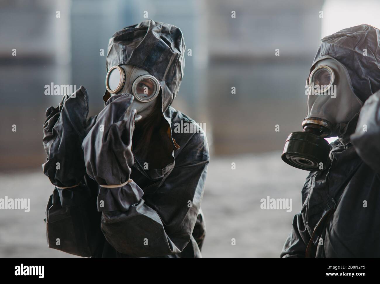 Zwei Personen in NBC-Schutzanzügen und Gasmasken. Konzept für vorbeugende Maßnahmen und Schutz für Coronavirus COVID 19 Pandemie und andere globale Stockfoto