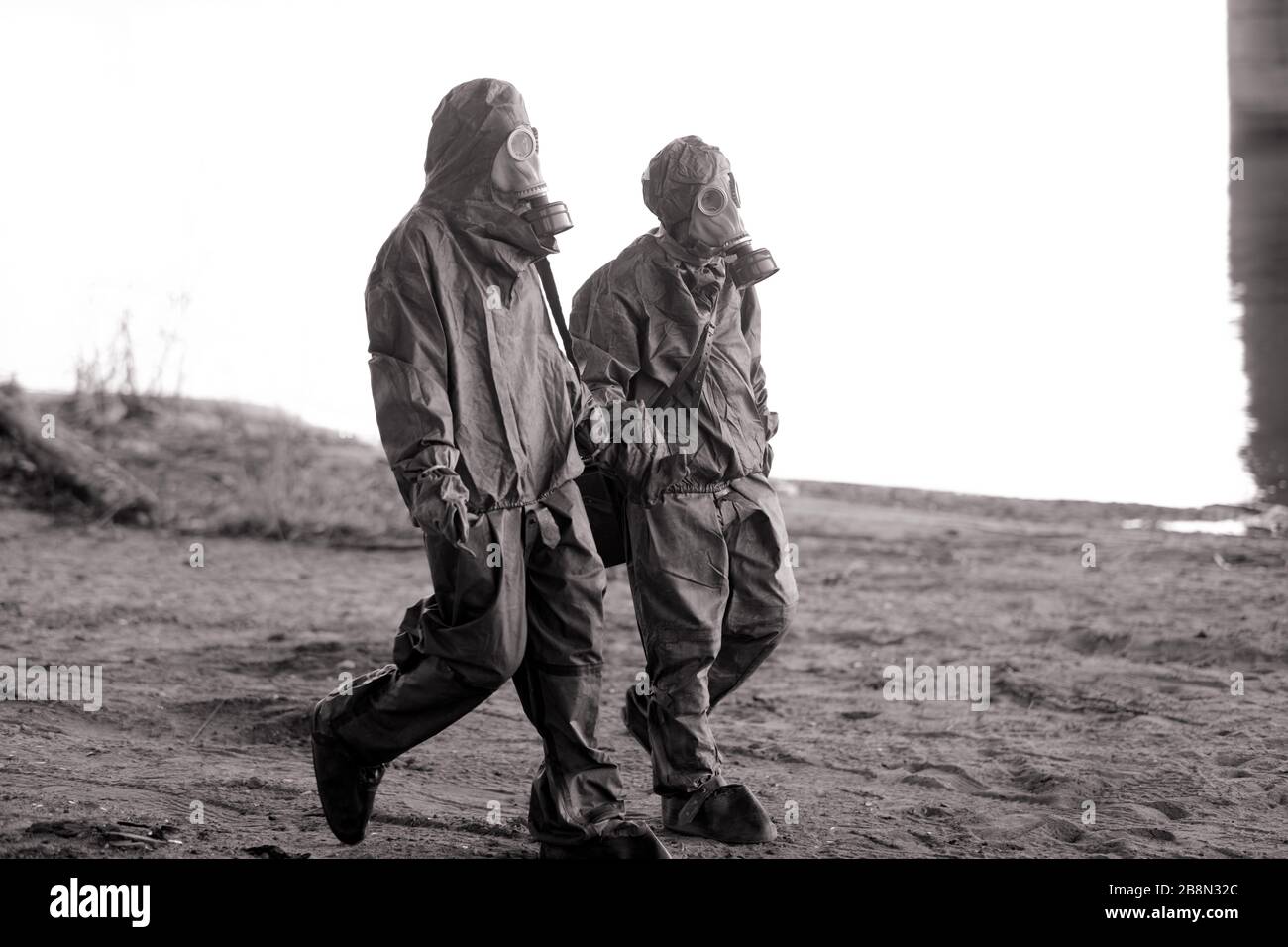 Zwei Personen wandern in NBC-Schutzanzügen und Gasmasken. Konzept für vorbeugende Maßnahmen und Schutz für Coronavirus COVID 19 Pandemie und andere g Stockfoto